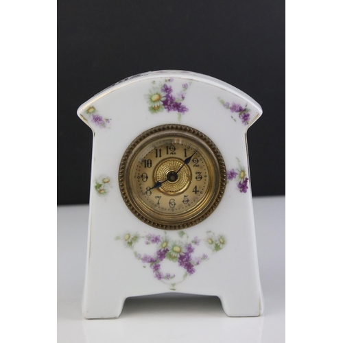 402 - An antique porcelain cased clock with floral decoration.