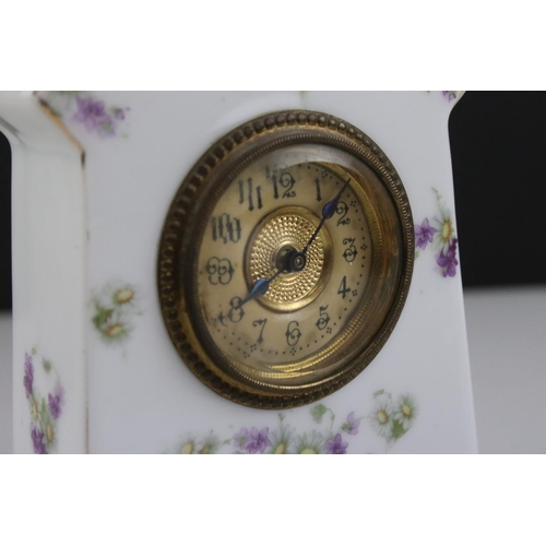 402 - An antique porcelain cased clock with floral decoration.