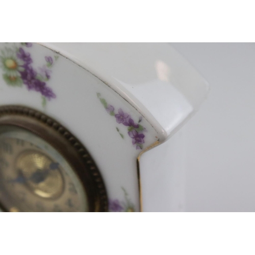 402 - An antique porcelain cased clock with floral decoration.