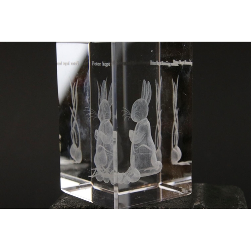 406 - A group of three clear glass paperweights, two with Beatrix Potter characters.