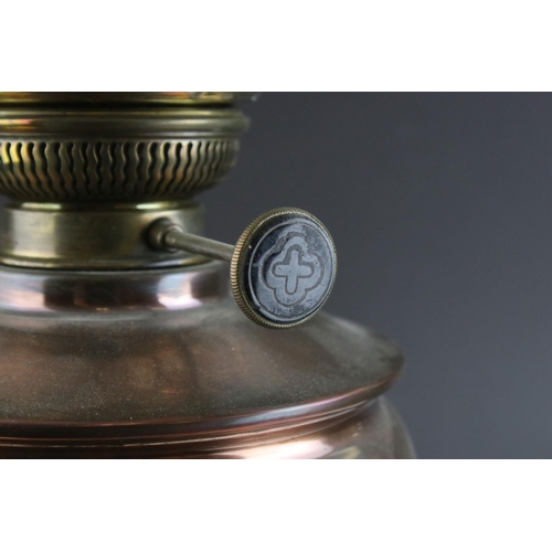 445 - An early 20th century brass and copper oil lamp complete with glass shade and chimney.