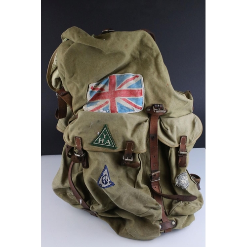 469 - A vintage cloth rucksack with metal frame work and leather strapping.