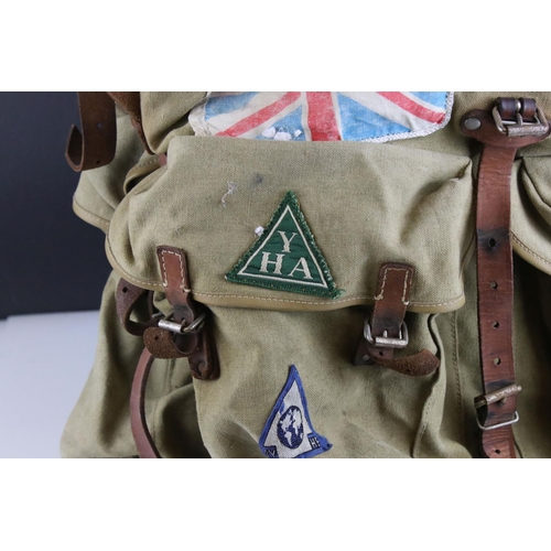 469 - A vintage cloth rucksack with metal frame work and leather strapping.