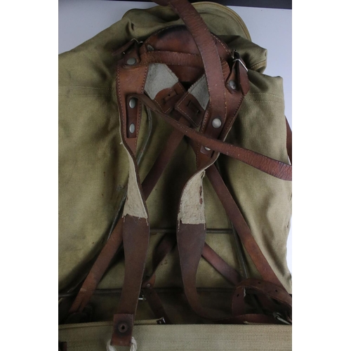 469 - A vintage cloth rucksack with metal frame work and leather strapping.