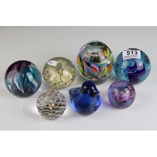 513 - A collection of seven glass paperweights to include Caithness examples.