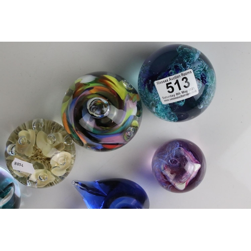 513 - A collection of seven glass paperweights to include Caithness examples.