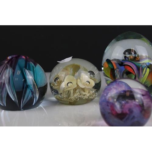 513 - A collection of seven glass paperweights to include Caithness examples.