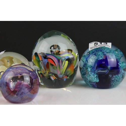 513 - A collection of seven glass paperweights to include Caithness examples.