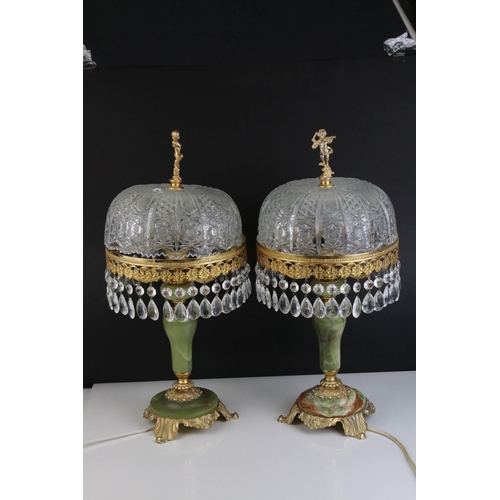 518 - A pair of green alabaster table lamps with gilt decoration and glass shades.