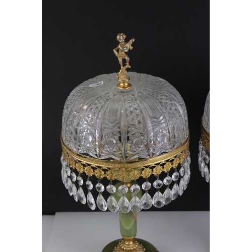 518 - A pair of green alabaster table lamps with gilt decoration and glass shades.