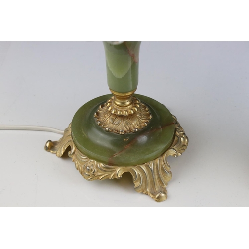 518 - A pair of green alabaster table lamps with gilt decoration and glass shades.