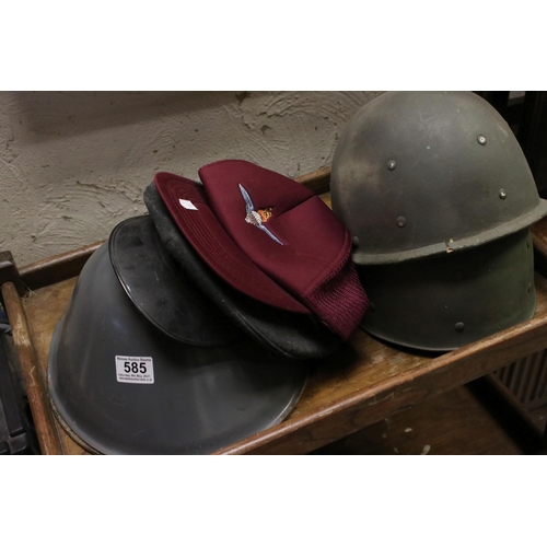 585 - A collection of nine military caps, helmets and berets to include a parachute regiment cap.