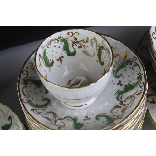 605 - An early 20th century white ground part tea set with swirling green and gilt decoration. Part of an ... 