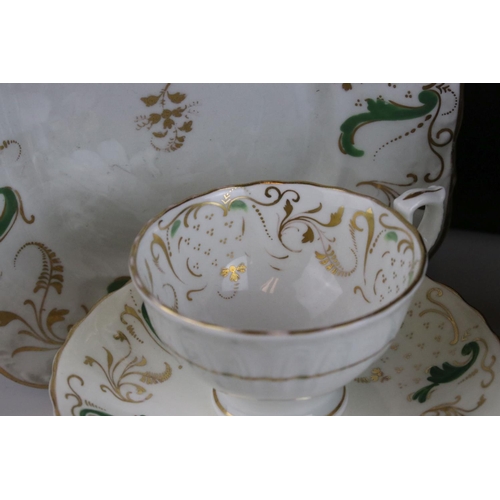 605 - An early 20th century white ground part tea set with swirling green and gilt decoration. Part of an ... 