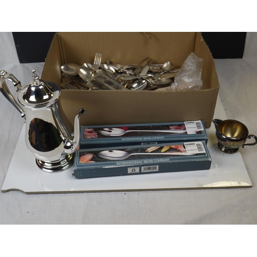 556 - A box of mixed silver plated items to include cutlery and a water jug.