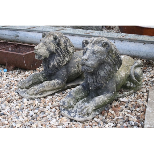 618 - A pair of vintage weathered lion statues, approx 58cm in length