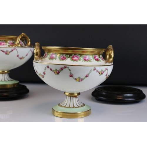 14 - Pair of Early 20th century Cauldon Ltd Twin Handled Urns, decorated with pink roses and with gilt hi... 