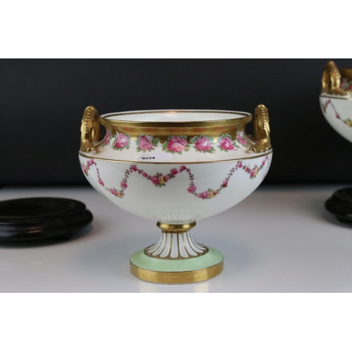 14 - Pair of Early 20th century Cauldon Ltd Twin Handled Urns, decorated with pink roses and with gilt hi... 