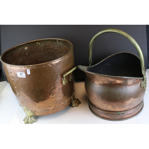 67 - A riveted copper coal bucket with brass lion feet together with another copper coal bucket.