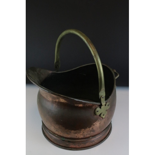 67 - A riveted copper coal bucket with brass lion feet together with another copper coal bucket.