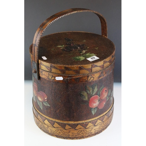 69 - An early 20th century lidded container with a handle, decorated with pokerwork and painted fruit. St... 