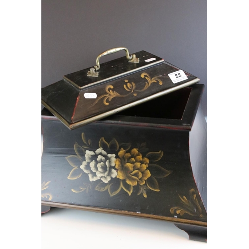 88 - A sarcophagus shaped black wooden box with hand painted decoration and velvet lined interior.