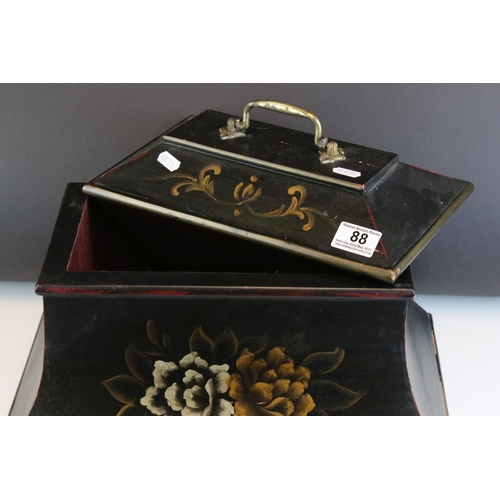 88 - A sarcophagus shaped black wooden box with hand painted decoration and velvet lined interior.