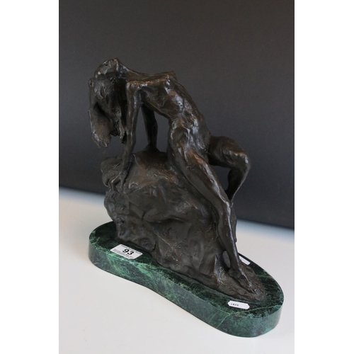 93 - Bronze figure of a nude woman reclining on a rock, on a green marble base