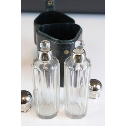 95 - Three glass perfume / cologne bottles with silver plated screw top lids and glass stoppers in a fitt... 