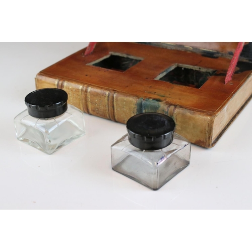 103 - Early 20th century double inkwell stand in the form of two leather bound antique books, 21cms wide