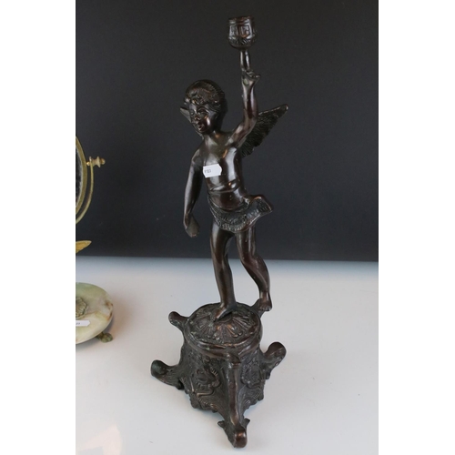 106 - Two bronzed cast metal candlesticks in the form of cherubs together with a mirror.