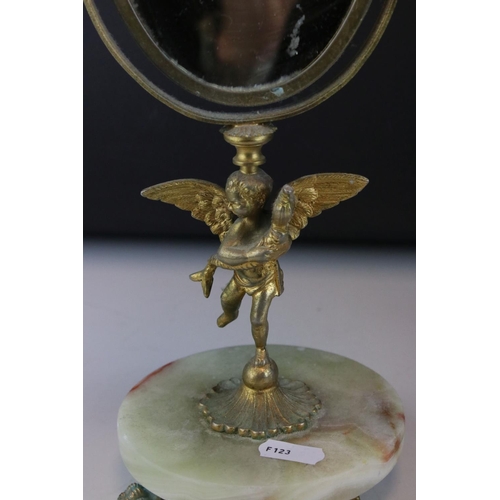 106 - Two bronzed cast metal candlesticks in the form of cherubs together with a mirror.