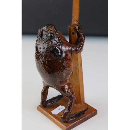 111 - A Taxidermy toad playing harp mounted to wooden stand.