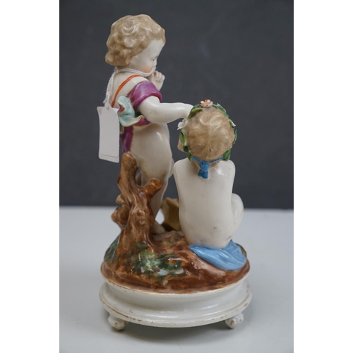 150 - A ceramic figurine of two cherubs with a birds nest, crossed swords mark to base.