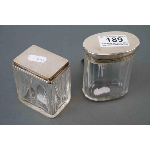 189 - A fully hallmarked sterling silver topped dressing table jar together with a silver plated example, ... 