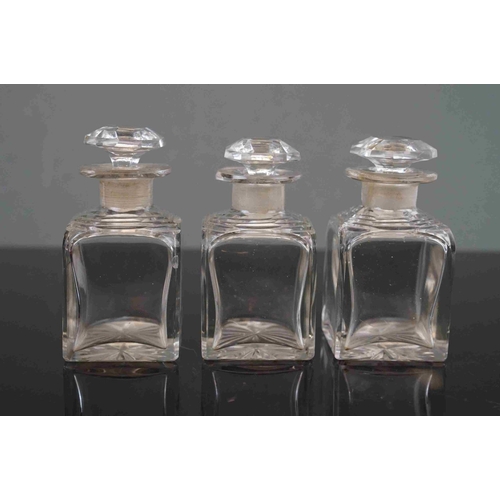 199 - An early 20th century Cased set of three cut glass cologne bottle's contained within a lined dome to... 