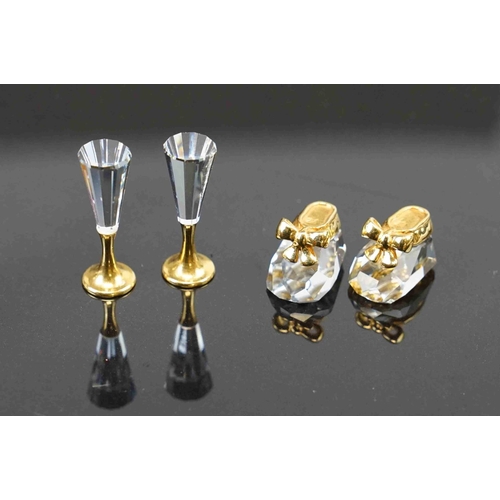 205 - A collection of Swarovski crystal miniatures to include pram, rattle, baby shoes and champagne glass... 