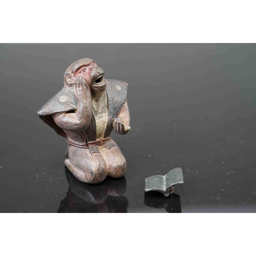 216 - An oriental metal figure of a monkey reading a book complete with box.