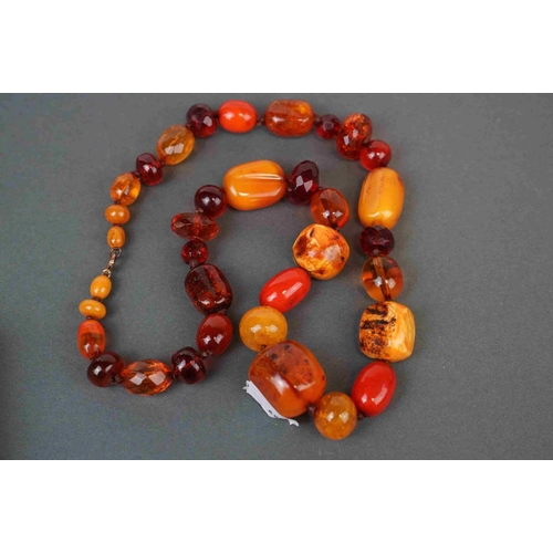 281 - A collection of four Amber style necklaces and a Amber style pendant on a yellow metal chain.