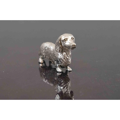 312 - A small group of three cast metal dog figures to include a dachshund.