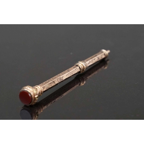 318 - An antique 9ct gold propelling pencil with carnelian finial.