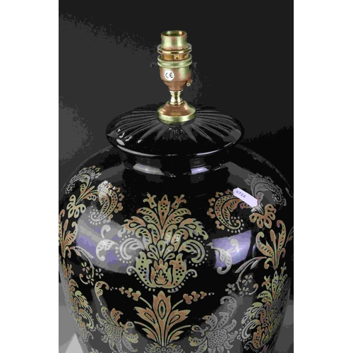 111 - A pair of  black ground contemporary lamps with stylized floral decoration.