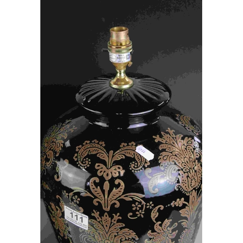 111 - A pair of  black ground contemporary lamps with stylized floral decoration.