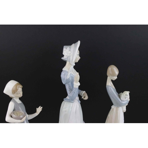 30 - Three Lladro figures girl with lamb, girl with goose and young woman with parasol.