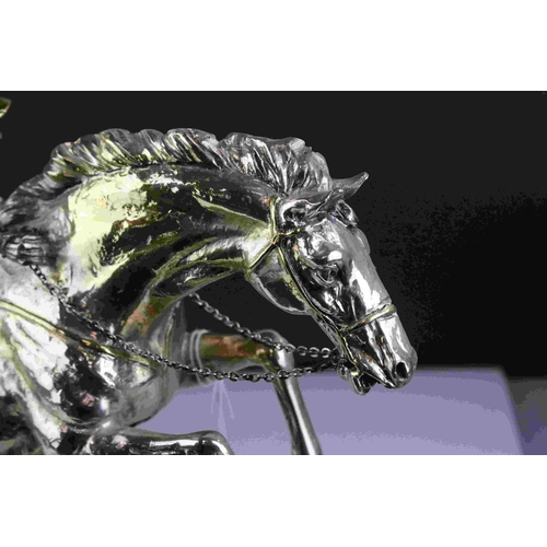 42 - Silver plated and gilt sculpture of a jockey and horse jumping hurdles signed Santini, 33cms high