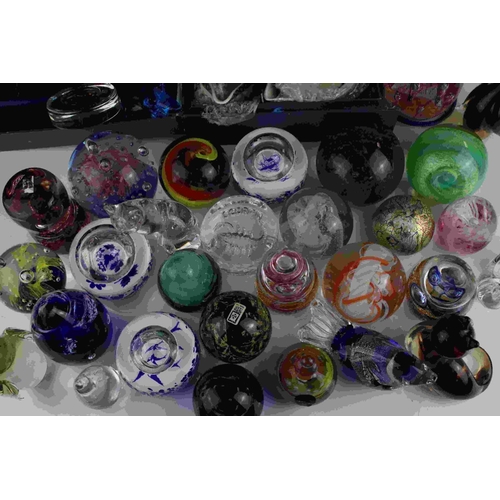 71 - A collection of over thirty glass paperweights to include Caithness examples.