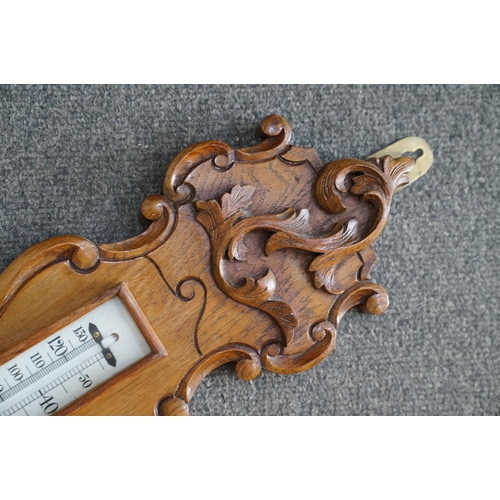 437 - A 20th century oak cased Barometer with carved and scalloped neck.