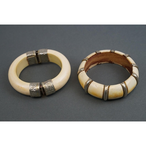 343 - Two vintage bone / tusk bangles with white metal fittings.