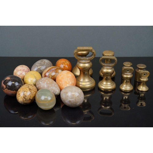 358 - A collection of eleven polished carved agate eggs together with a selection of Avery brass weights.