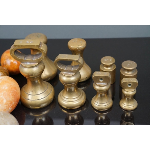 358 - A collection of eleven polished carved agate eggs together with a selection of Avery brass weights.